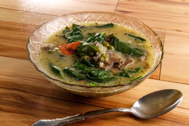 Kremalı mantar ve ıspanaklı ve bezelyeli pirinç çorbası.