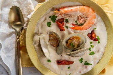 Taze sıcak New England midye çorbası, karides kraker ve maydanozlu garnitür.