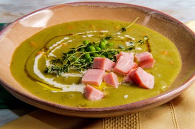 İngiliz bezelye çorbası, küp jambon ve serpiştirilmiş krema ve zeytinyağı.