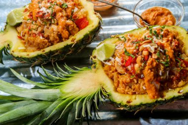 Ananas kasesinde sriracha ve fıstık ezmesi soslu Tayland kaju tavuğu pilavı. 