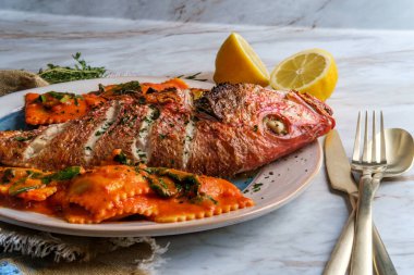 Şeri şarabı pembesi soslu ravioli ile kafa kafaya yenen deniz ürünleri.