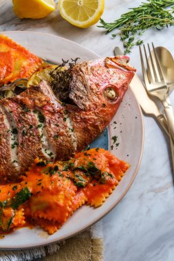 Şeri şarabı pembesi soslu ravioli ile kafa kafaya yenen deniz ürünleri.