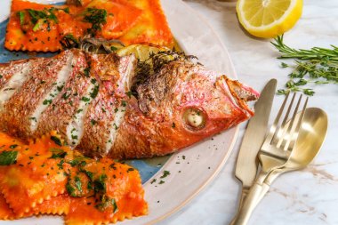 Şeri şarabı pembesi soslu ravioli ile kafa kafaya yenen deniz ürünleri.