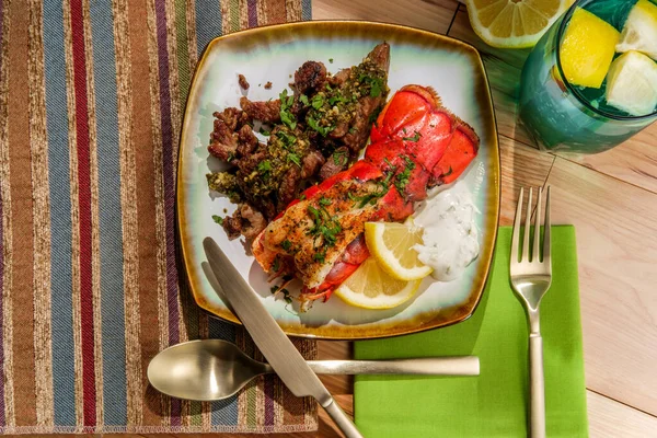 Surf and turf lobster and steak tips with tartar sauce and pesto