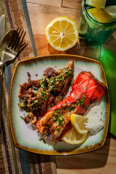 Surf and turf lobster and steak tips with tartar sauce and pesto