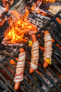 Pastırmalı sosisli sandviç. Kamp ateşi odununda kızartılmış.