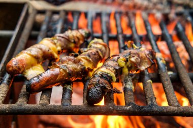 Pastırmalı sosisli sandviç. Kamp ateşi odununda kızartılmış.