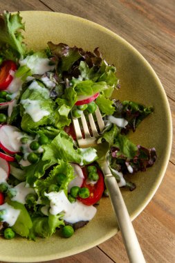 Bahar karışımlı yeşil bezelye salatası turp dilimlenmiş vişneli domates ve çiftlik sosu.