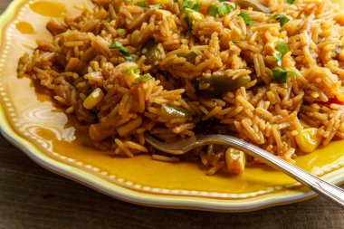 Meksika usulü vejetaryen baharatlı İspanyol pirinci, dolma biberli mısır ve kişniş.