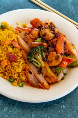 Baharatlı Çin soslu sebze ve kızarmış domuz pirinci.