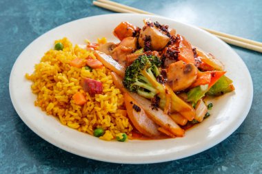 Baharatlı Çin soslu sebze ve kızarmış domuz pirinci.