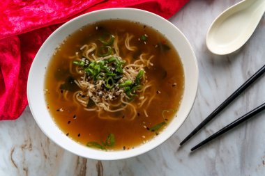 Japon miso eriştesi çorbası smokin susam tohumları ve garnitür olarak dilimlenmiş soğan.