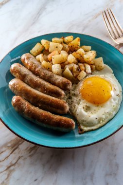 Kızarmış güneşli tarafı, sosisli ve patatesli Amerikan yumurtalı kahvaltısı.