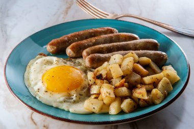 Kızarmış güneşli tarafı, sosisli ve patatesli Amerikan yumurtalı kahvaltısı.
