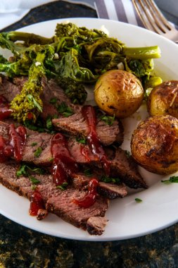 Biftek ve ballı yeni patates, barbekü sosu ve sarımsaklı brokoli haham.