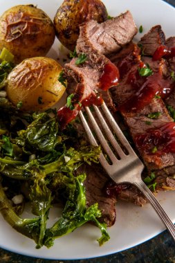 Biftek ve ballı yeni patates, barbekü sosu ve sarımsaklı brokoli haham.