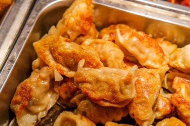 Büfe tepsisi dolusu kızarmış Asya yemeği, domuz etli börek.