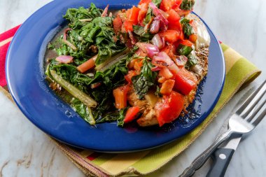 İtalyan usulü bruschetta tavuğu sotelenmiş sarımsaklı İsviçre pazarıyla servis edilir.