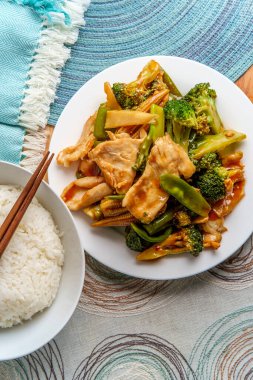 Çin usulü Hunan usulü baharatlı tavuk, yanında sotelenmiş sebze ve beyaz pirinç.