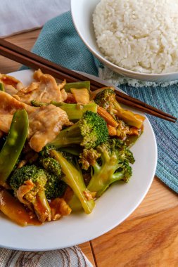 Çin usulü Hunan usulü baharatlı tavuk, yanında sotelenmiş sebze ve beyaz pirinç.