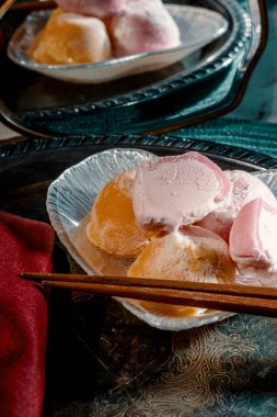 Traditional Japanese strawberry and mango mochi ice cream on marble kitchen table with romantic moody dramatic lighting clipart