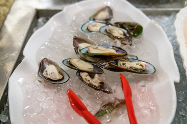 Buz üzerinde soğuk servis edilen taze midye istiridyeleri.