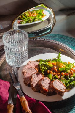 Kızarmış domuz filetosu ve lahana yeşili, siyah bezelye salatası.
