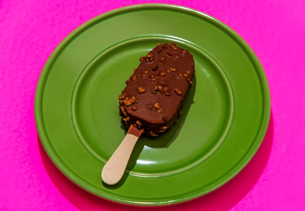 Chocolate coated icecream bar on stylized modern neon pink background
