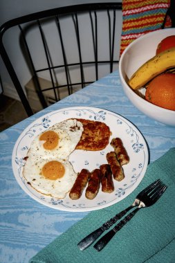 Tam Amerikan kahvaltısı. İki kızarmış güneşli tarafı yumurta, sosis ve kızarmış patates.