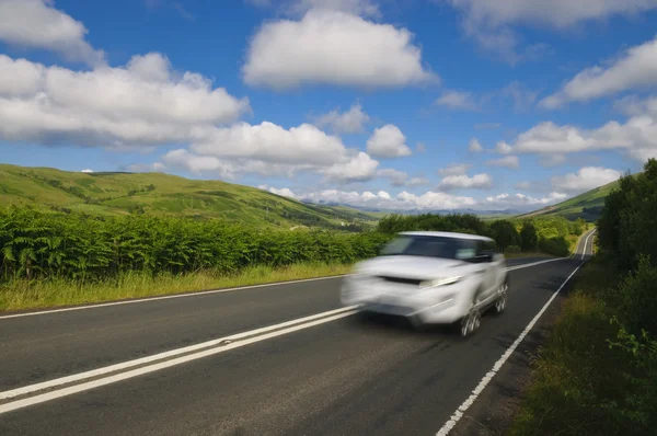 El exceso de velocidad del coche en la carretera escocesa Fotos De Stock
