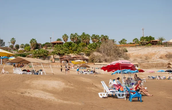 Mensen ontspannen op het strand aan de oevers van de dode zee — Stockfoto