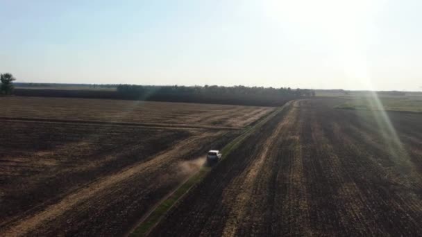 Vista superior para o carro em movimento. Drone está seguindo para um carro passeios em cross country com uma enorme poeira nuvens, poeira de baixo das rodas. tiro drone — Vídeo de Stock