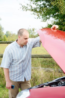 Arabanın yakınında duran yetişkin adam