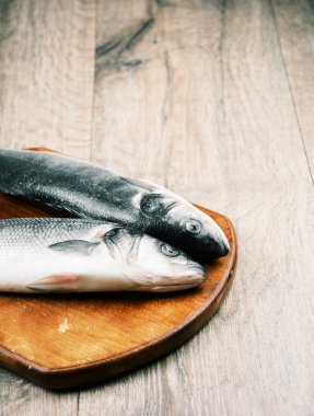 Ahşap tahta üzerinde çiğ levrek balığı