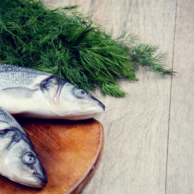 Ahşap tahta üzerinde çiğ levrek balığı