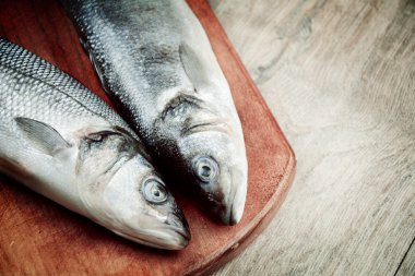 Ahşap tahta üzerinde çiğ levrek balığı