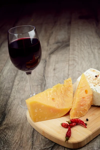 Cheese on the table with glass of wine — Stock Photo, Image