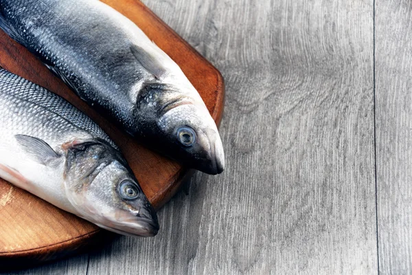 Çiğ levrek balık üzerinde ahşap