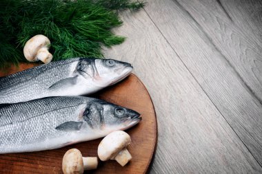 Ahşap tahta üzerinde çiğ levrek balığı