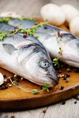 Ahşap tahta üzerinde çiğ levrek balığı