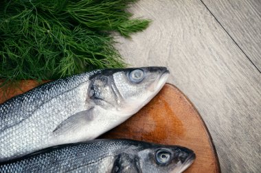Ahşap tahta üzerinde çiğ levrek balığı