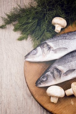 Ahşap tahta üzerinde çiğ levrek balığı