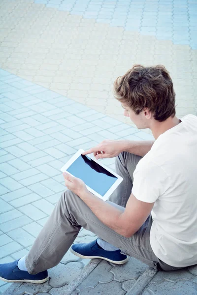 Young man is using a tablet — Stock Photo, Image