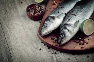 Ahşap tahta üzerinde çiğ levrek balığı