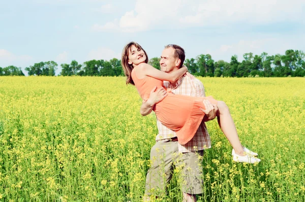 Lycklig man och kvinna i gult äng — Stockfoto