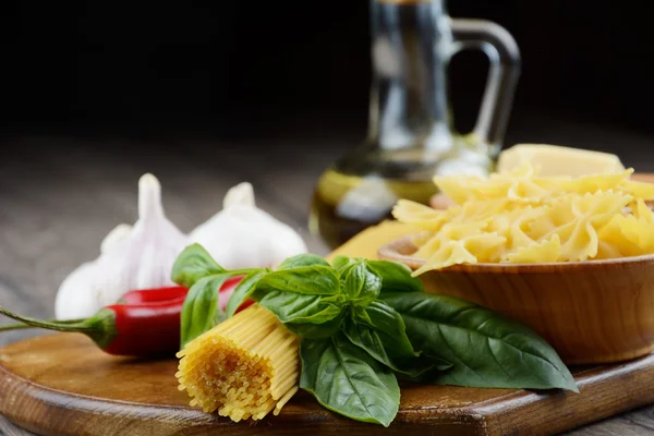 Esparguete cru e macarrão farfalle na mesa — Fotografia de Stock