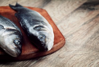 Ahşap tahta üzerinde çiğ levrek balığı