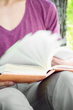 Genç adam oturmuş ve bir kitap okuma