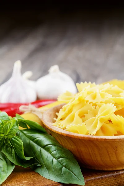 Esparguete cru e macarrão farfalle na mesa — Fotografia de Stock