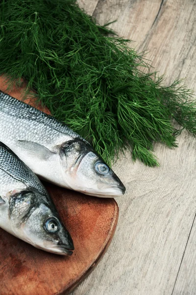 Ahşap tahta üzerinde çiğ levrek balığı